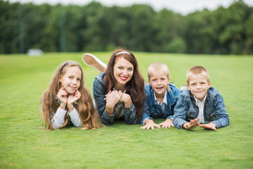 Fototapeta premium Mother and children on the grass