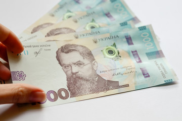 New 1000 ukrainian money hryvnia in hand on white background. Concept of getting salary, devaluation, inflation