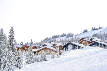 Ski resort with beautiful wooden chalets next to the slope 