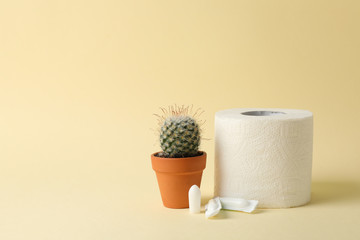 Toilet paper, candles and cactus on beige background. Hemorrhoids