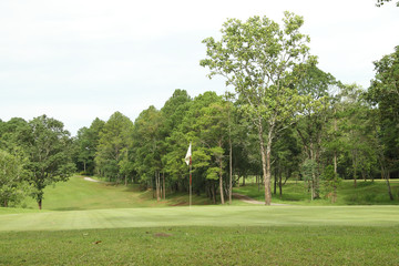 The evening golf course has sunlight shining down at golf course in Thailand