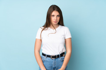 Teenager caucasian girl isolated on blue background with sad expression