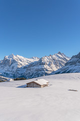 Verschneite Winterlandschaft mit einsamer Berghütte in den Schweizer Bergen