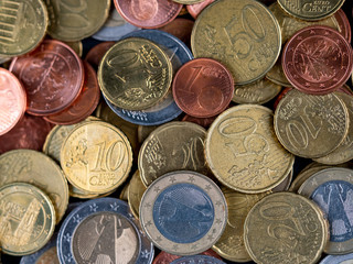 Verschiedene Euro-Münzen auf schwarzer Tafel