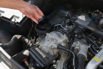 Mécanicien  auto contrôlant le niveau d'huile, de liquide de refroidissement, le serrage de la roue, la vidange, le liquide de frein, la mécanique de la voiture et faisant l'entretien courant