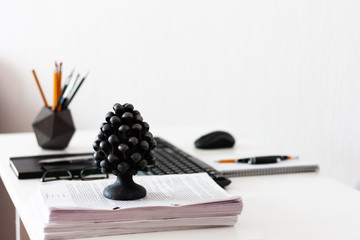 Home office, modern workplace: white table, keyboard laptop computer, concrete holder with pencils...