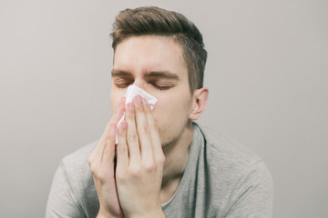 White man gets sick and blows his nose into a white napkin
