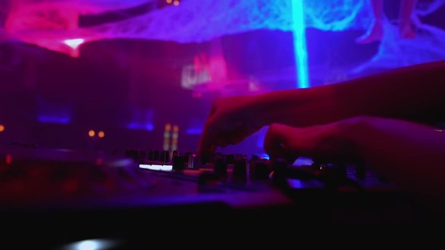 Woman working at dj mixer, playing records in dance club, electronic music