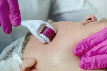 Obraz na płótnie Canvas Cosmetologist performs a facial massage using a mesoscooter. Wom
