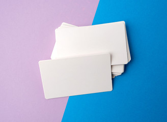 Fototapeta na wymiar stack of rectangular white blank business cards on a blue background