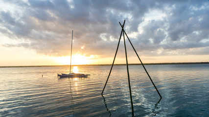 sailing boat in sea at sunset