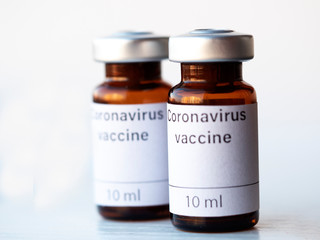 The photo illustration shows two vials labeled Coronavirus vaccine and syringe.
