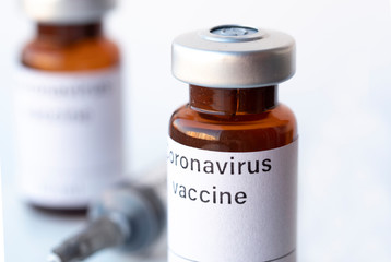 The photo illustration shows two vials labeled Coronavirus vaccine and syringe.