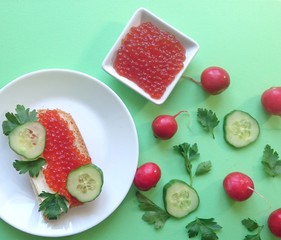 Red caviar of salmon fish, sandwich, cucumber, parsley.
