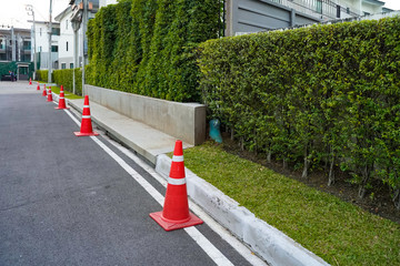 Red and white plastic witches hat cone traffic warning sign no parking on the road,applying along...