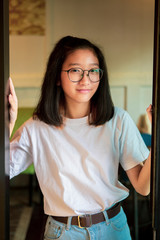 smiling face of asian teenager standing at home door