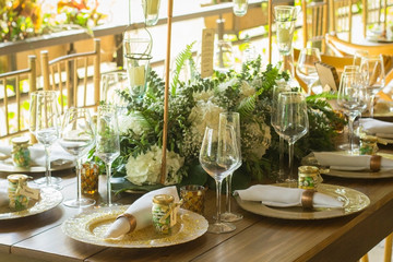 table decorated with flowers, glasses and candles, for the reception of a wedding