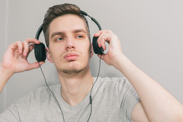 A young handsome man on the couch listening to music. Stay home