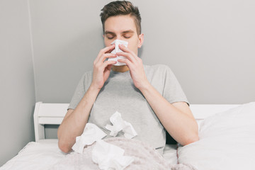 White man gets sick and blows his nose into a white napkin