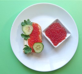 Red caviar of salmon fish, sandwich, cucumber, parsley.