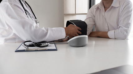 Close up of doctor is measuring blood the pressure man on arm in the hospital