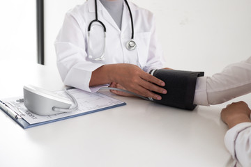 Close up of doctor is measuring blood the pressure man on arm in the hospital