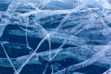The natural texture of cracked ice of Lake Baikal. Clear blue ice. Layered thick ice. Horizontal.