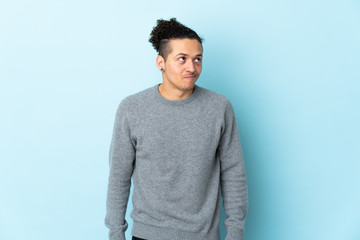 Caucasian man over isolated background having doubts while looking up