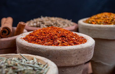 Indian spices collection, dried colorful condiment, nuts, pods and seeds and another spices in clay bowls