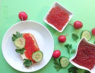 Red caviar of salmon fish, sandwich, cucumber, parsley.