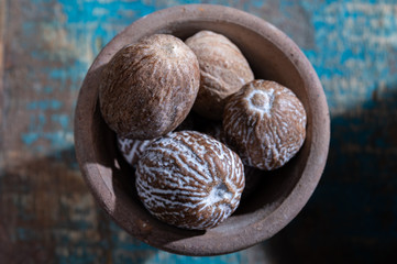 Indian spices collection, dried whole nutmeg and another spices in clay bowls