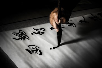 Hand of a chinese calligrapher writing beautiful characters with a brush in Qufu, China