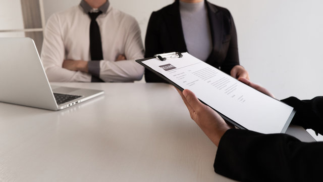 Interview employee talking about resume and job description with the job seeker sitting in front