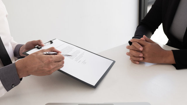 Interview employee reading a resume with the job seeker sitting in front