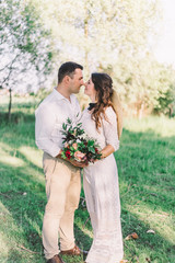 Naklejka premium A pair of newlyweds in stylish boho style outfits. looking at each other