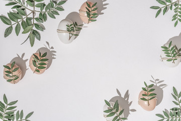 Creative flat lay composition with easter eggs and natural branches. Natural sun light lighting and sharp shadows. Realistic aesthetic look. Contemporary style.