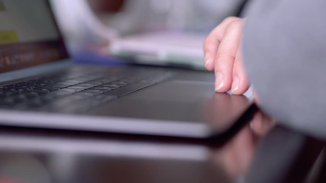 Person Scrolling on Laptop Profile Side. Person scrolling on laptop computer side angle to hand on tracking pad