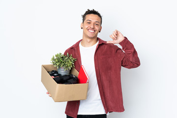 Caucasian man making a move while picking up a box full of things over isolated white background...