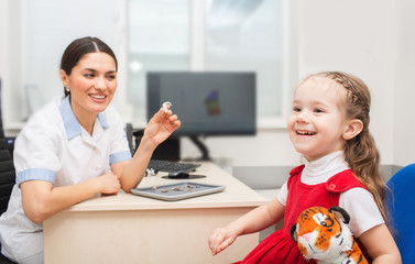 Little girl patient is very pleased that she will now hear sounds of surrounding world using...
