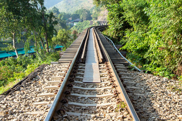 The railway tracks slope along mountains and forests in Asia.