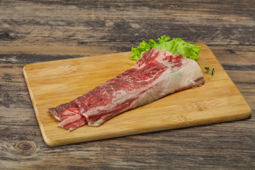 Raw beef bacon over wooden board