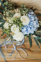 Wedding bouquet for the bride. Flowers in blue, white colors. Ingredients: hypericum, rose cream, hydrangea (sort Peppermint blue), phlebodium, pittosporum (sort Nigra) and other ornamental foliage.