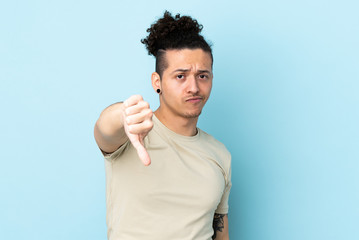 Caucasian man over isolated background showing thumb down with negative expression