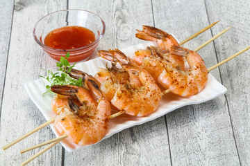 Grilled prawn skewer with sauce