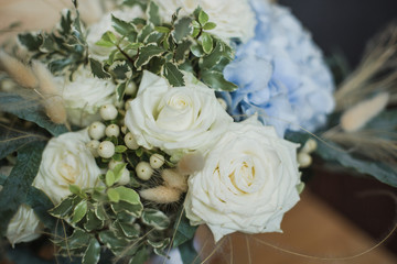 Wedding bouquet for the bride. Flowers in blue, white colors. Ingredients: hypericum, rose cream, hydrangea (sort Peppermint blue), phlebodium, pittosporum (sort Nigra) and other ornamental foliage.