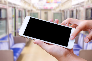 woman hand hold and touch screen smart phone or cell phone over blurred  train background
