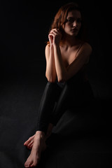 Obraz premium Portrait of a young curly girl in a dark studio