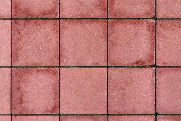 The texture of the square pavers is red with wet spots.