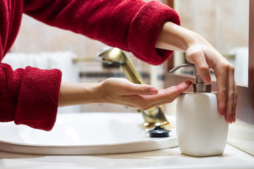 Woman washing her hands on the sink of the bathroom at home