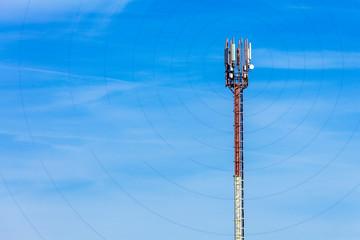 Antenna telephone tower on sky background with communication signal diverging in different directions by waves